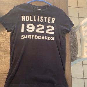 A small navy blue hollister shirt with 1922 surfboards in lettering on the front
